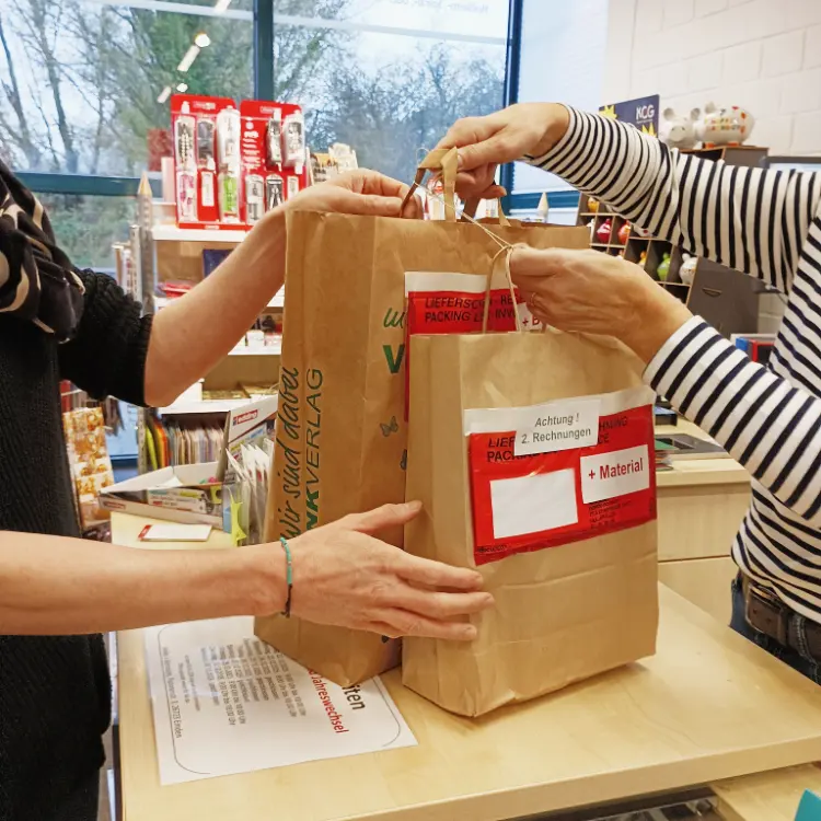 Material und Schulbücher werden in Tüten verpackt an den Kunden überreicht